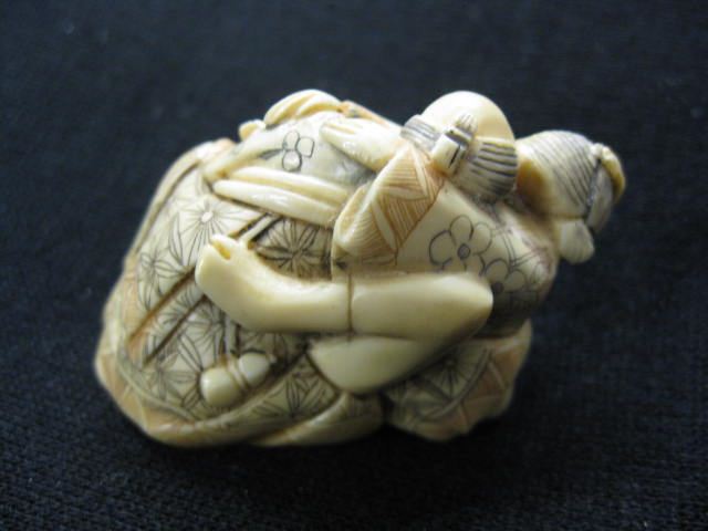 Appraisal: Carved Ivory Erotic Netsuke of a Couple fancy polychrome work