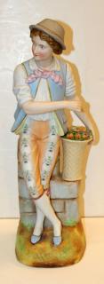 Appraisal: Porcelain statue of a boy with fruit basket Porcelain statue