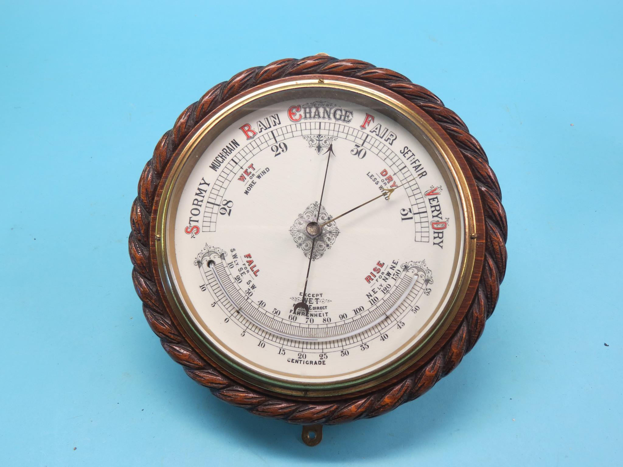 Appraisal: A late Victorian aneroid barometer circular-shape in carved oak rope-twist