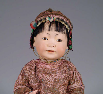 Appraisal: JDK ORIENTAL BABY A larger Oriental baby with olive-colored skin