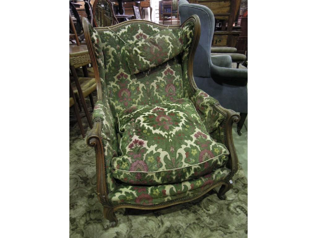 Appraisal: A continental wing armchair with floral cut moquette upholstery within