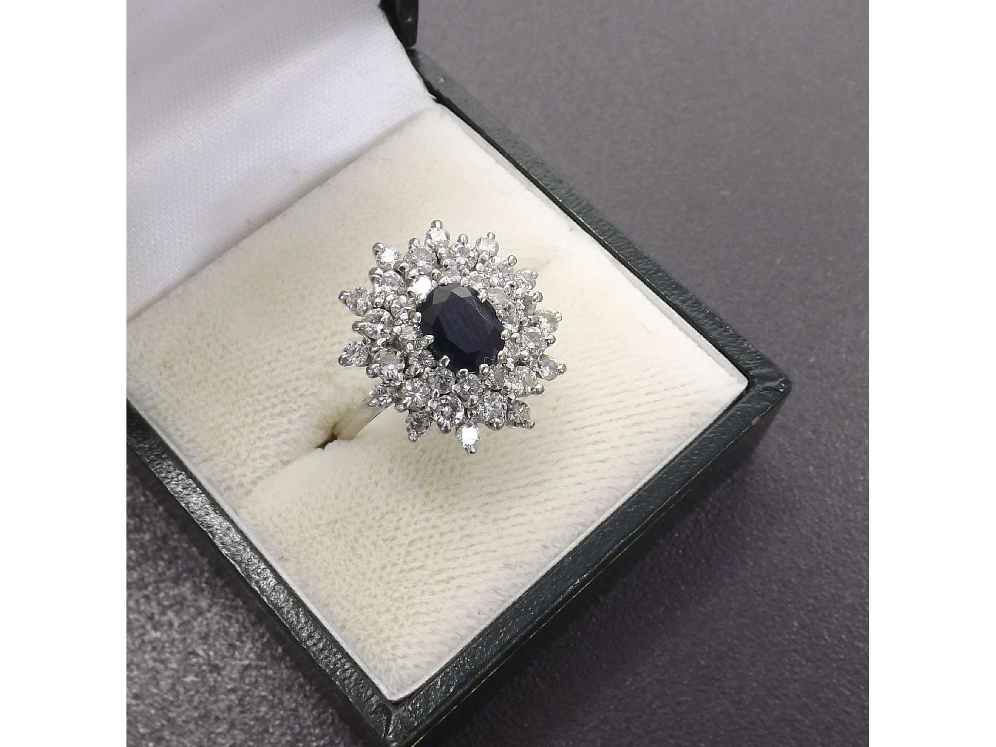 Appraisal: Fancy dark blue sapphire and diamond cluster ring the oval