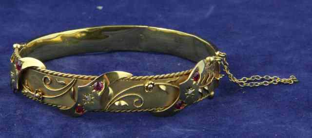 Appraisal: A ct gold hinged bracelet set three scrolls each with