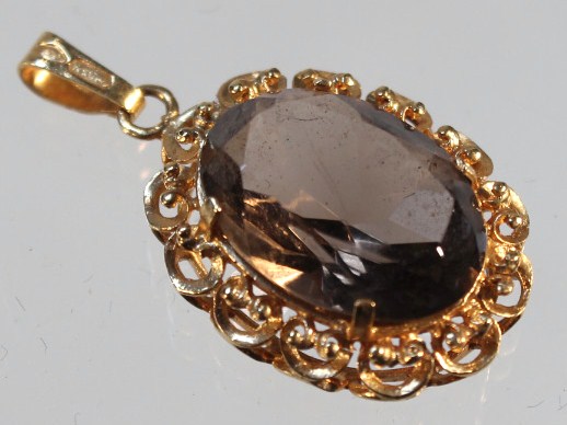 Appraisal: A smoky quartz pendant with a clasp end claw set