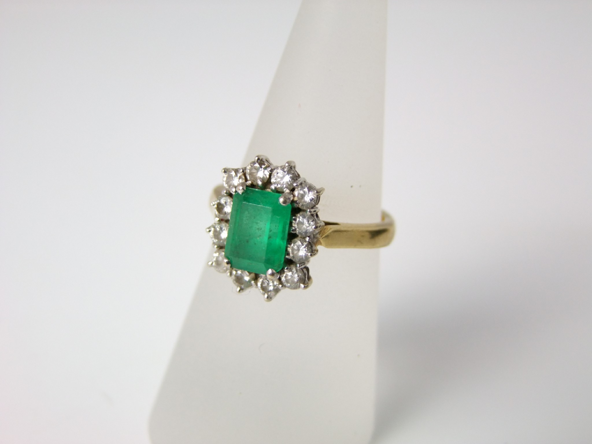 Appraisal: An ct gold emerald and diamond cluster ring the baguette