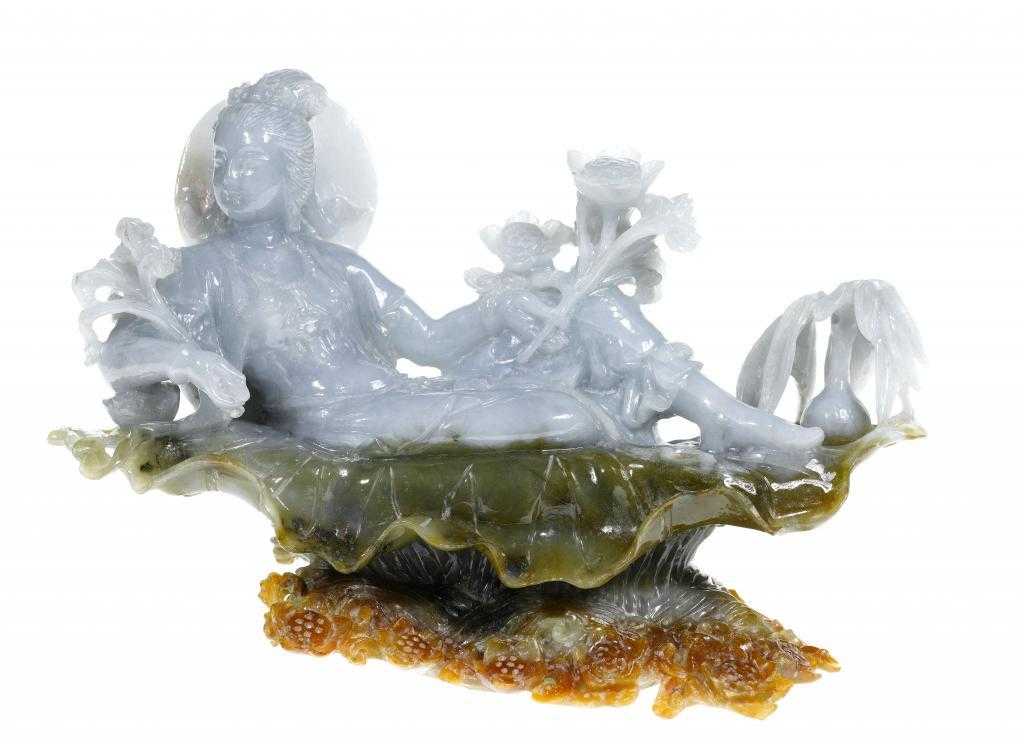 Appraisal: A CHINESE JADE CARVING OF GUANYIN semi-reclining on a lotus