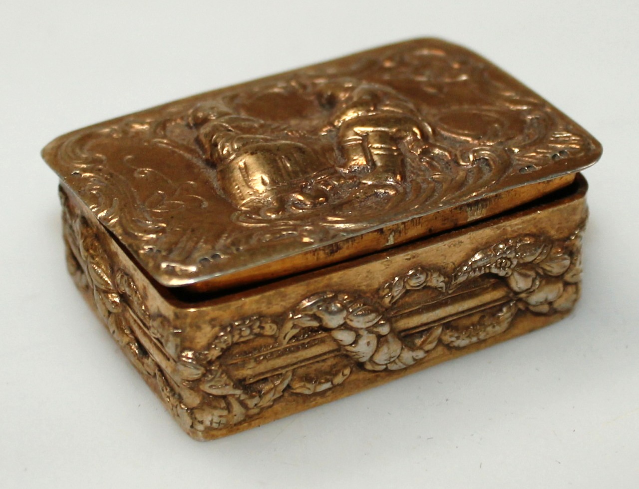 Appraisal: A patch box with oblong top repouss decorated with figures