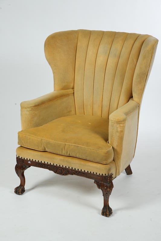 Appraisal: WINGBACK CHAIR Carved frame with yellow upholstery on claw feet