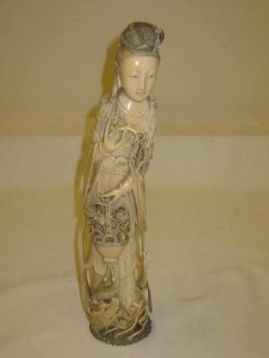 Appraisal: A CHINESE IVORY OKIMONO modelled as a lady in traditional