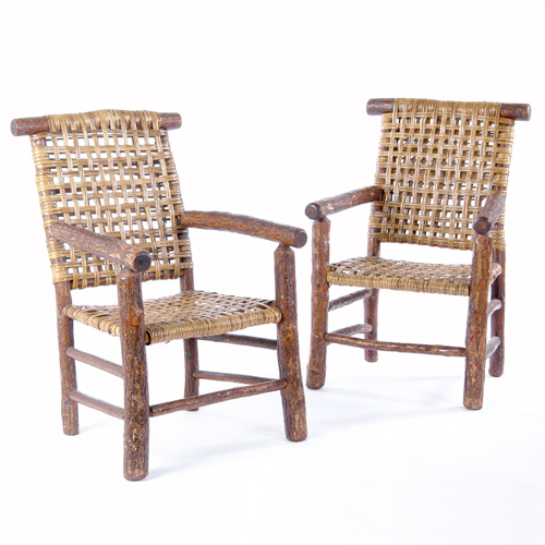 Appraisal: RUSTIC Pair of armchairs with log construction and woven cane