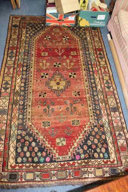 Appraisal: A RUST GROUND SHIRAZ RUG with central lozenge medallion within