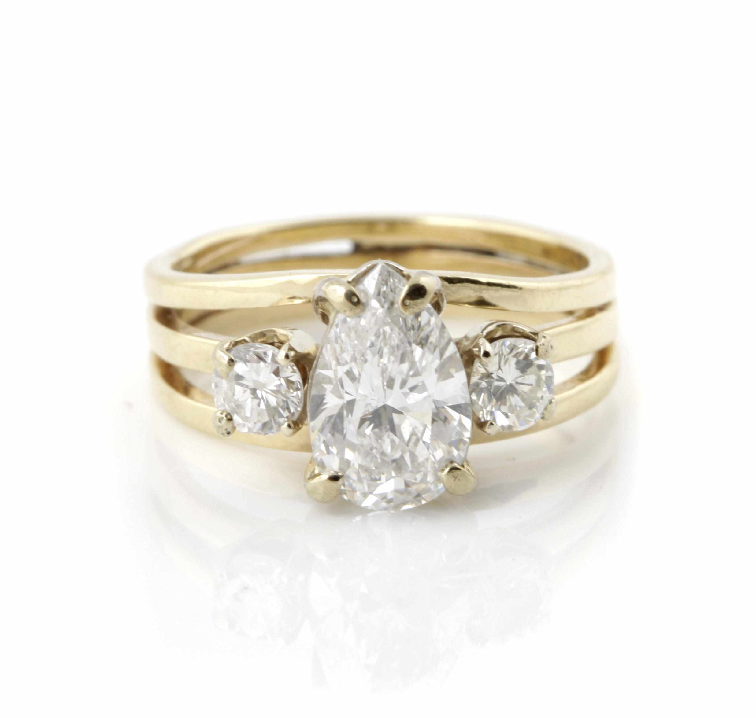 Appraisal: A diamond and bicolor gold three stone ring centering a