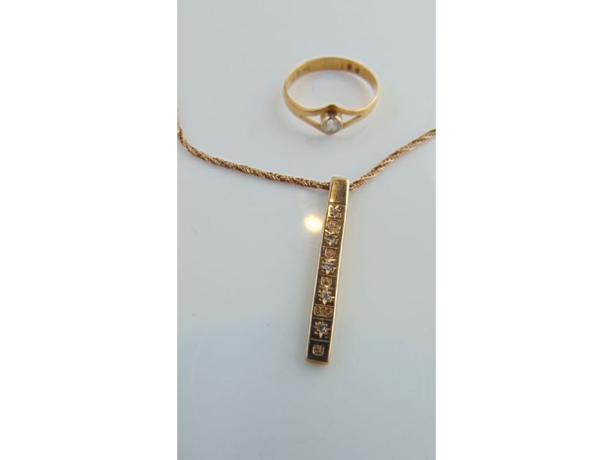 Appraisal: A ct gold bar pendant highlighted with five single-cut diamonds