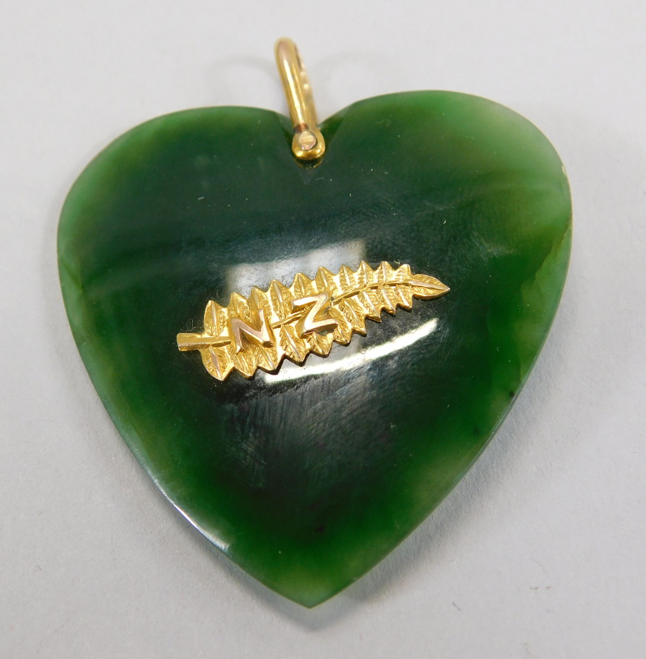 Appraisal: A heart shaped jade pendant with attached gold leaf and