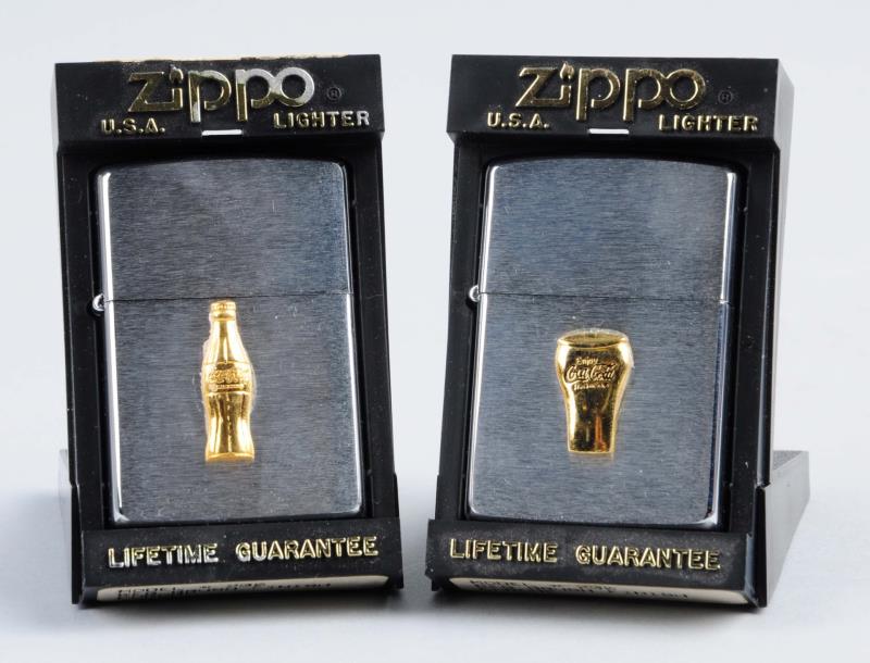 Appraisal: Pair Of Coca-Cola Zippo Lighters This lot includes two Zippo