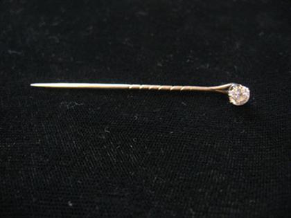 Appraisal: Single diamond stick pin Prong set stick pin features one