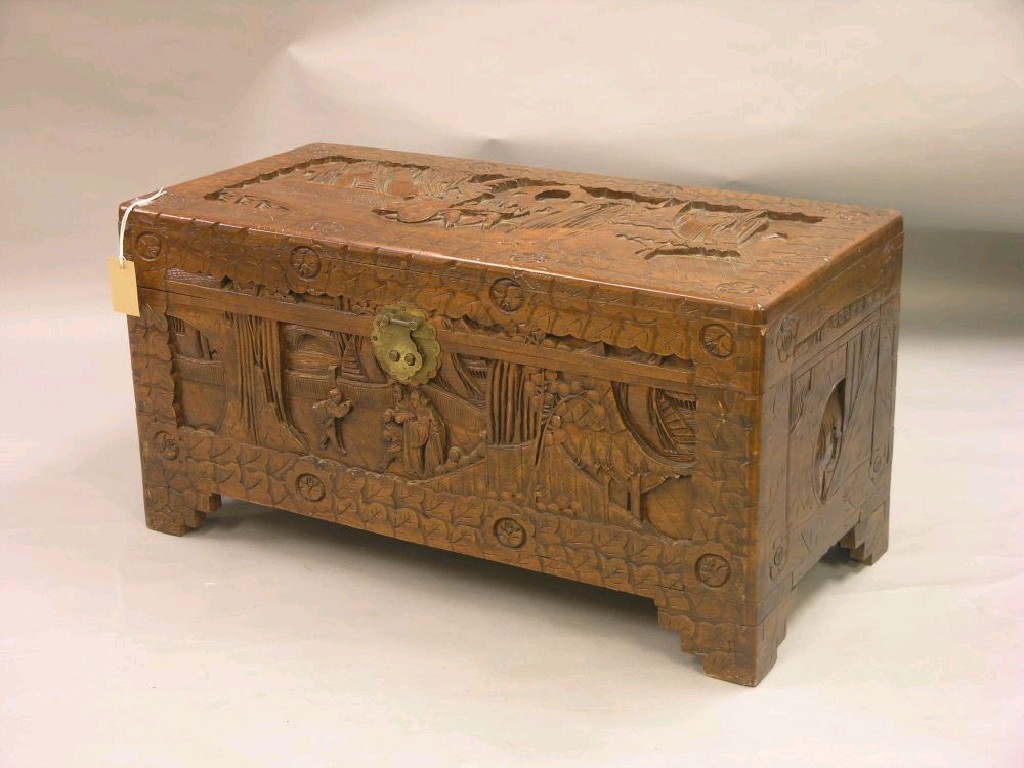 Appraisal: A small Chinese camphorwood trunk carved on all sides with