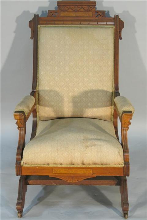 Appraisal: AMERICAN EASTLAKE WALNUT ROCKING ARMCHAIR circa the stepped cresting with