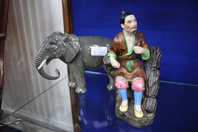 Appraisal: AN ORIENTAL PORCELAIN FIGURINE OF A SEATED FAGGOT GATHERER cm