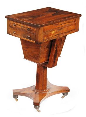 Appraisal: A Victorian rosewood sewing table the crossbanded top above an