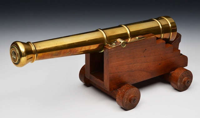 Appraisal: A BRASS TABLE TOP CANNON supported by a wooden carriage