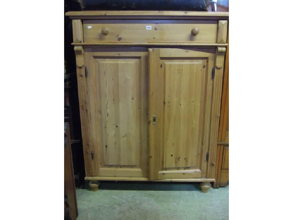 Appraisal: A stripped pine side cupboard fitted with a frieze drawer