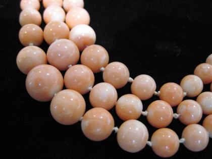 Appraisal: Tri-strand light pink coral bead necklaceOf graduated form karat yellow