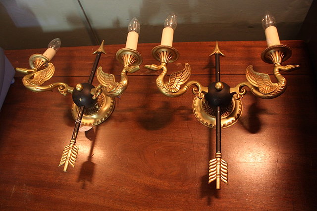 Appraisal: A PAIR OF GILT METAL AND EBONISED METAL WALL LIGHTS