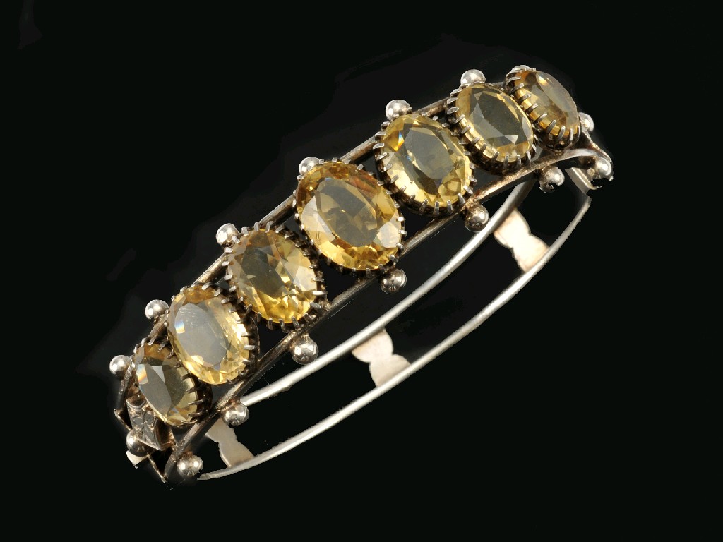 Appraisal: A Citrine Bangle the front claw-set seven graduated oval-cut stones