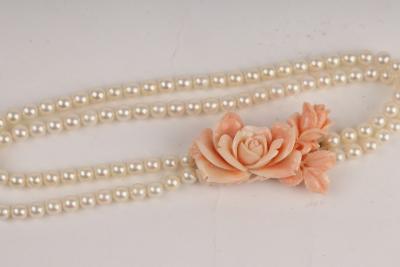 Appraisal: A two-row cultured pearl necklace with carved coral clasp set