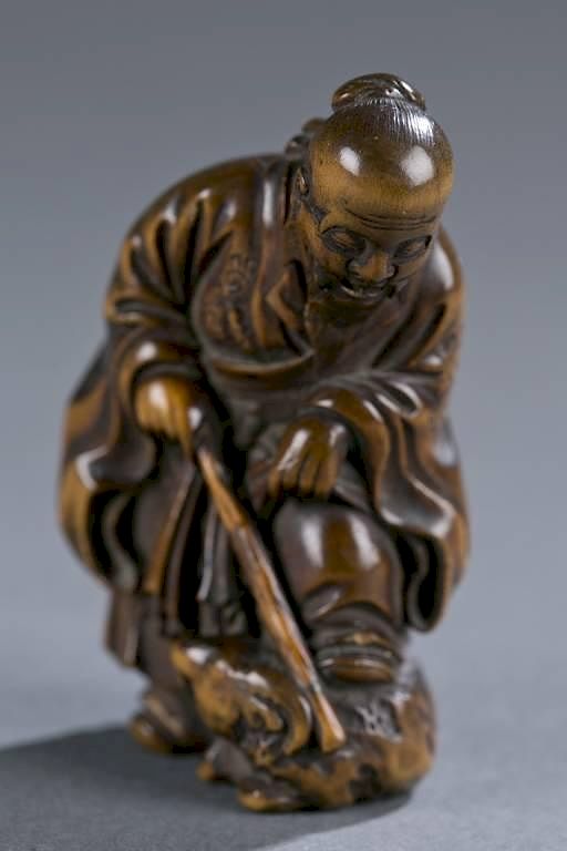 Appraisal: Japanese wood netsuke of man with foot on a ram