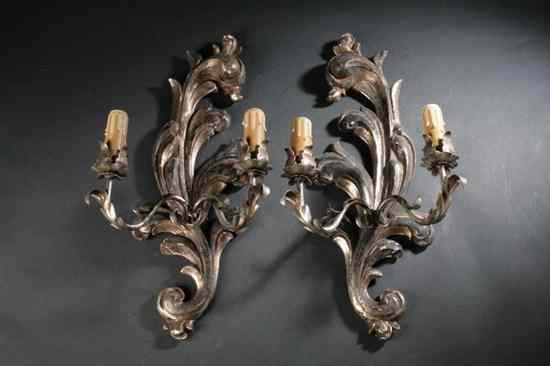 Appraisal: PAIR VENETIAN ROCOCO-STYLE SILVERED WOOD TWO-LIGHT SCONCES th century Scrolling