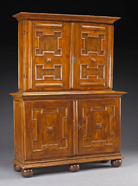 Appraisal: A Continental Baroque fruitwood cupboard In two parts the upper