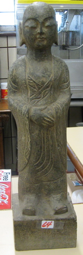 Appraisal: AN ASIAN GRANITE SCULPTURE depicting a standing Buddha raised on