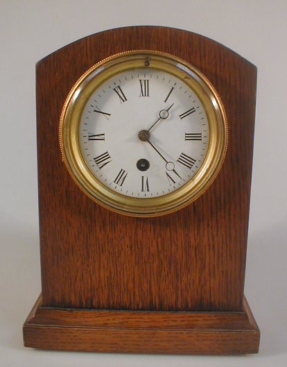 Appraisal: An oak cased mantel clock with a timepiece movement the