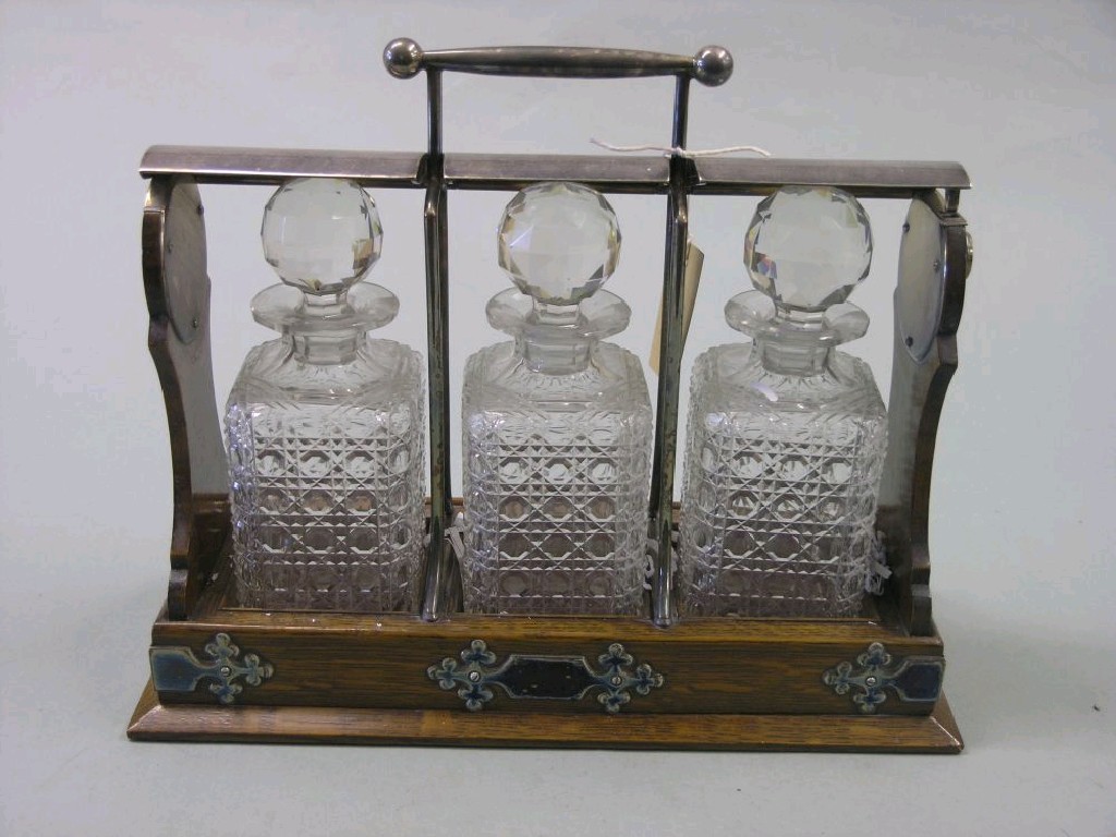 Appraisal: A late Victorian oak tantalus with silver plated mounts three