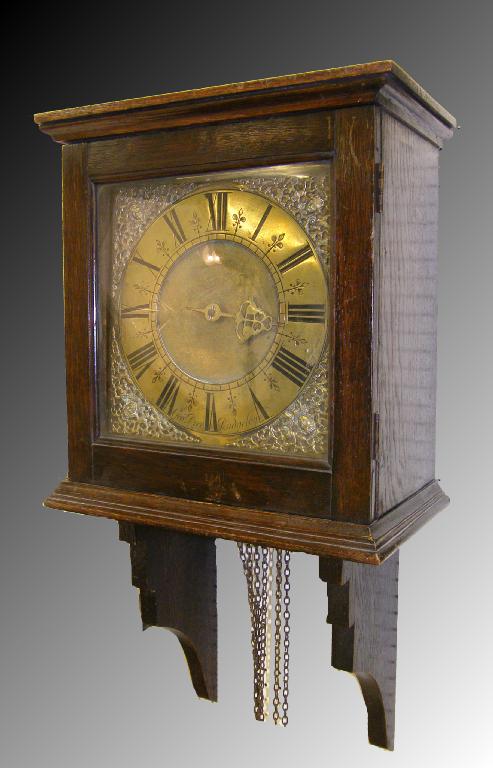 Appraisal: Oak hooded thirty hour wall clock the square brass dial