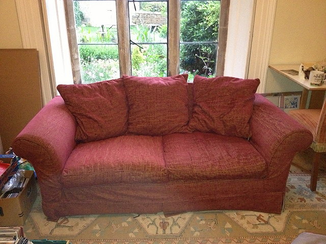 Appraisal: A PAIR OF TWO SEATER SOFAS each upholstered in red