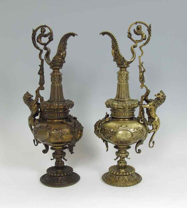 Appraisal: PAIR TH C BRONZE EWERS Highly ornamental with lions ''climbing''