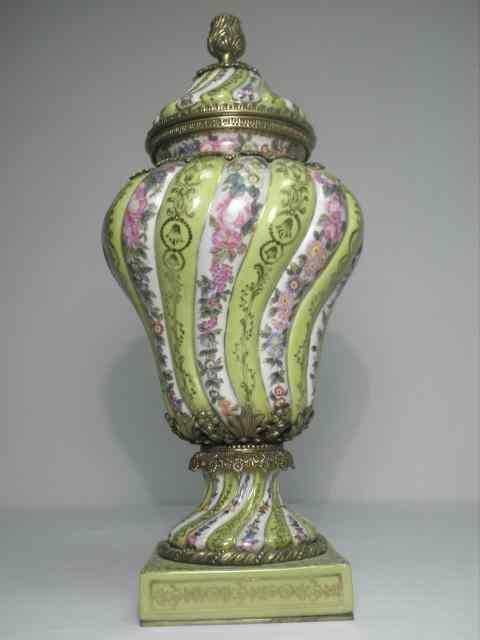 Appraisal: Porcelain and brass hand painted covered urn Swirled style porcelain