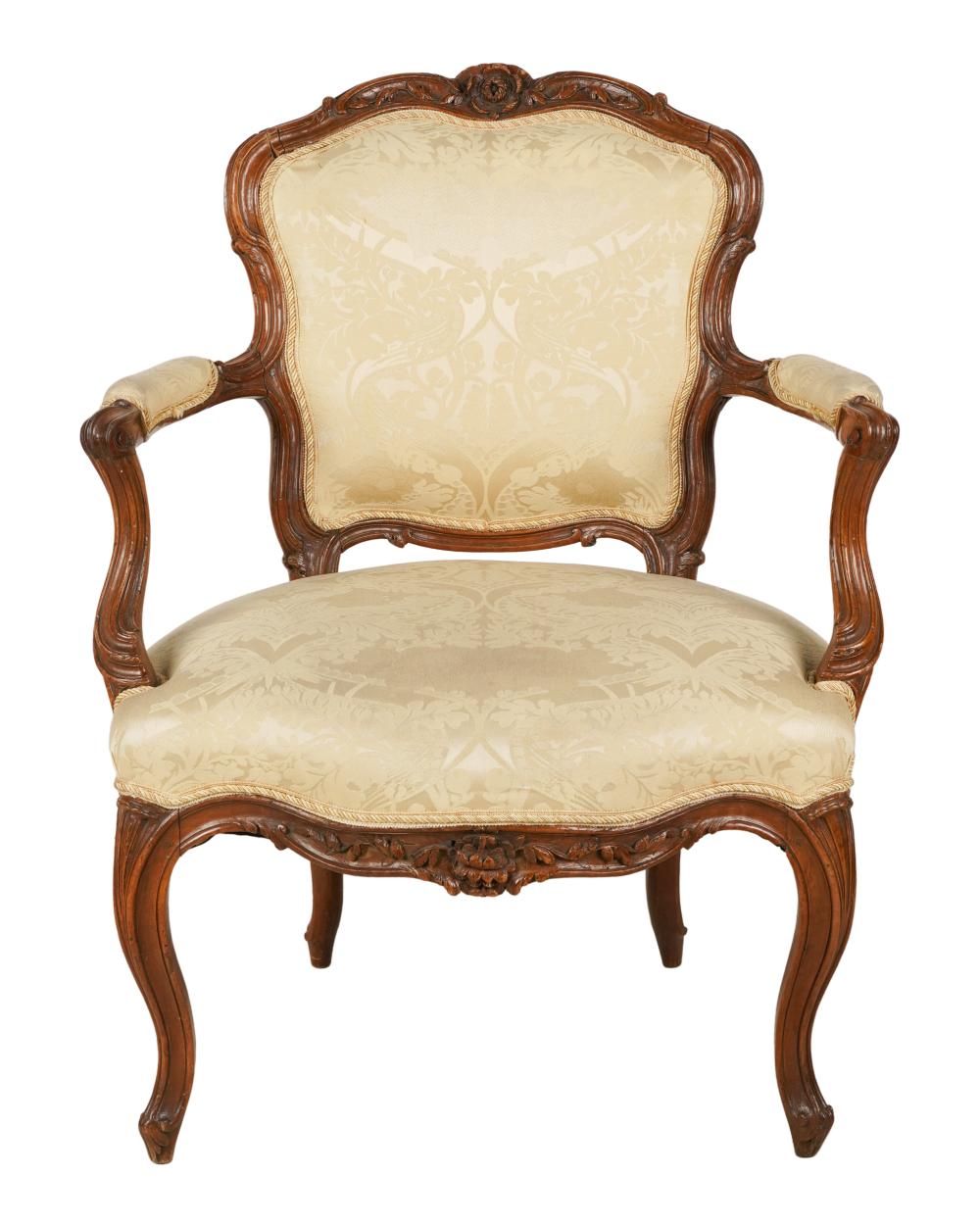 Appraisal: FRENCH PROVINCIAL WALNUT FAUTEUILlate th century covered with cream-colored damask