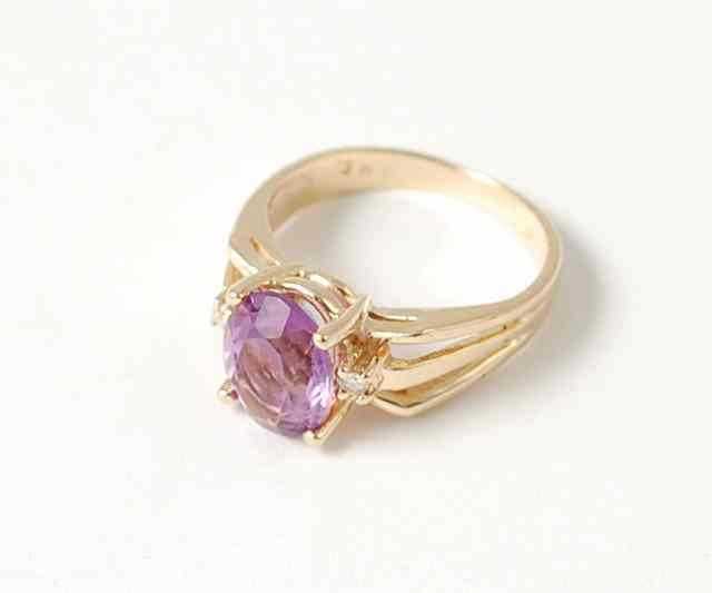 Appraisal: AMETHYST DIAMOND AND FOURTEEN KARAT GOLD RING centering an oval-cut