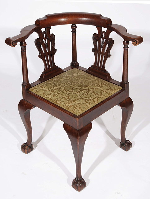 Appraisal: A GEORGE III MAHOGANY CORNER CHAIR with carved splat backs