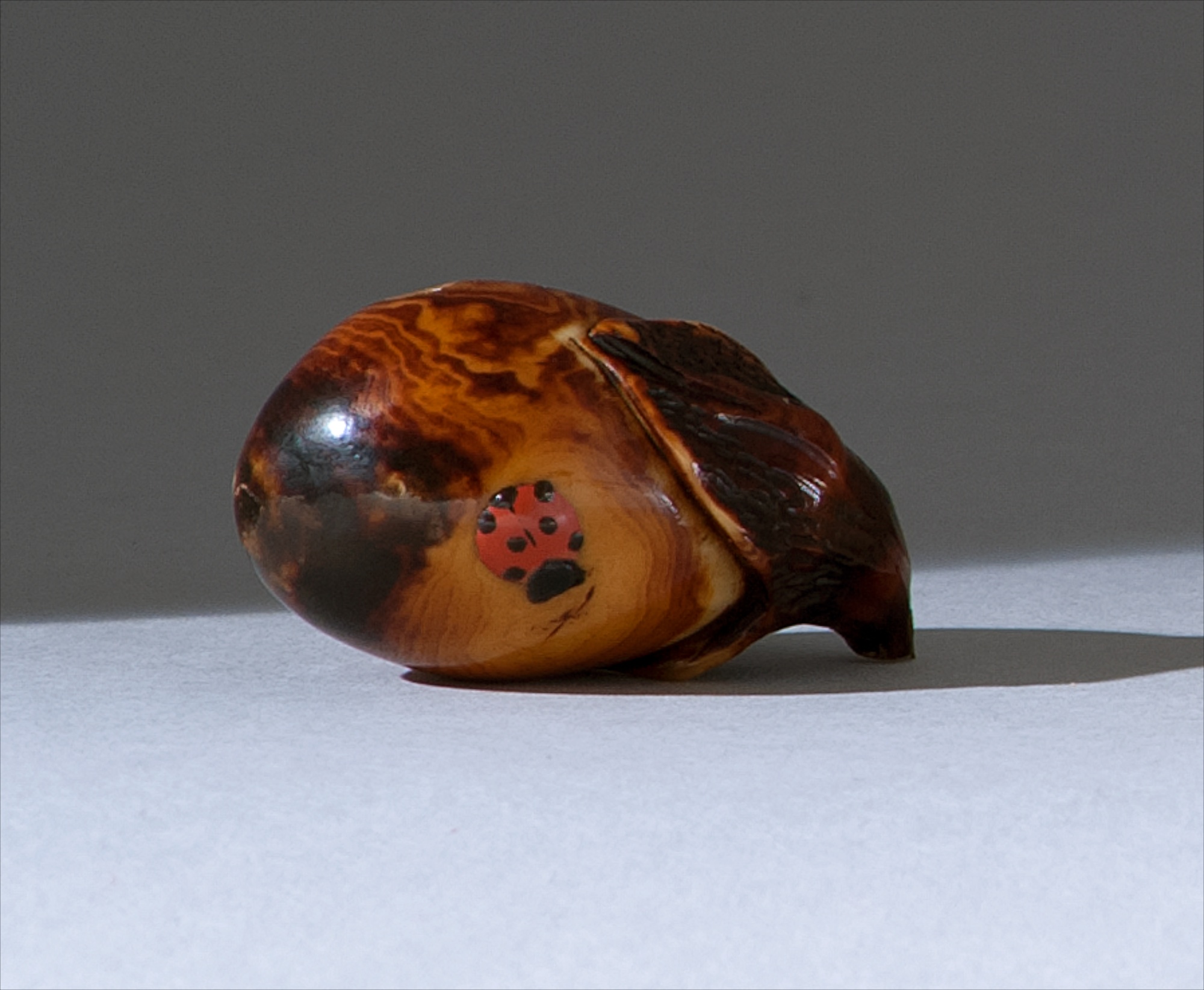 Appraisal: LACQUER-ON-IVORY NETSUKE Circa By Shumin In the form of an