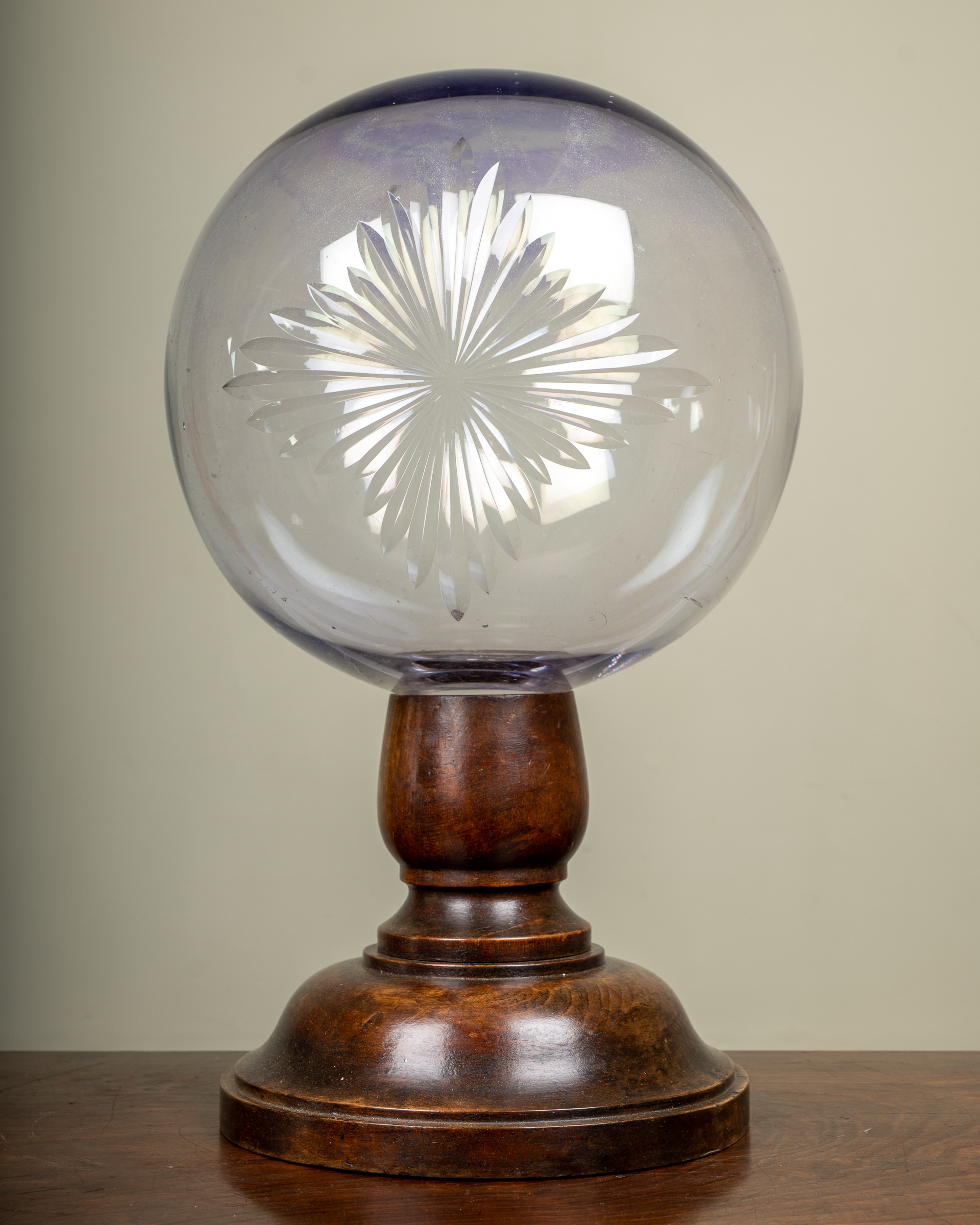 Appraisal: A Victorian star cut glass sphere on a turned wooden