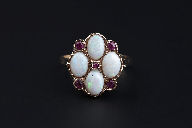 Appraisal: AN OPAL AND RUBY PANEL RING set with four oval