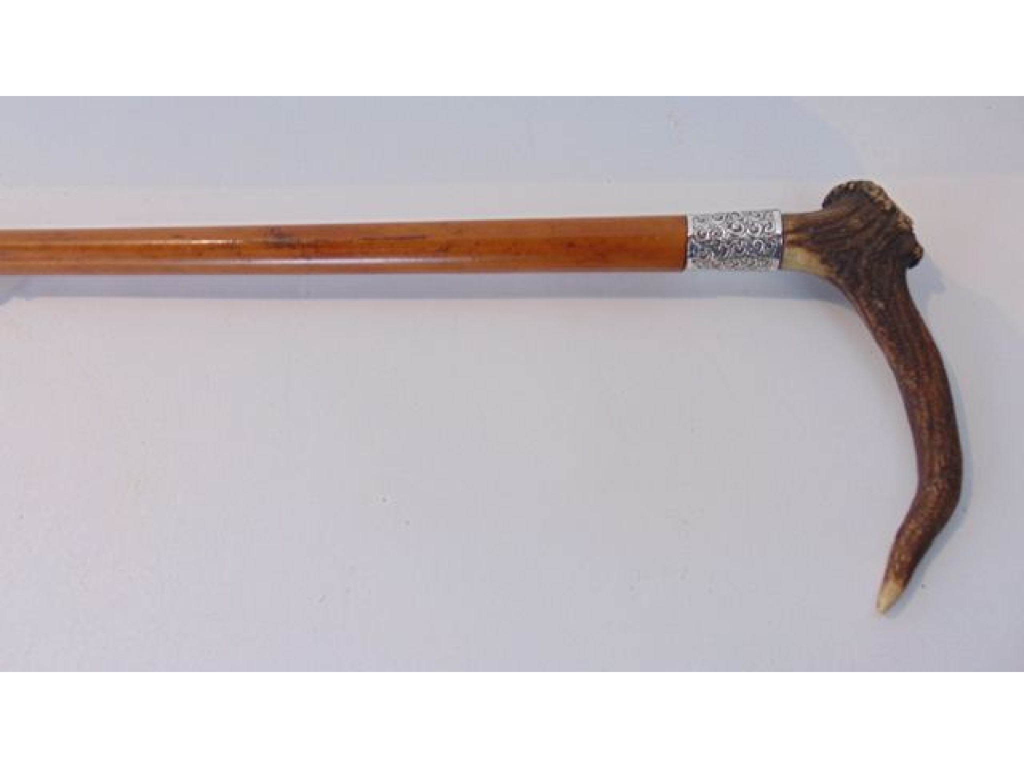 Appraisal: A Malacca walking cane with applied antler handle set before