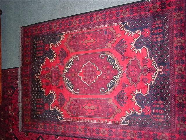 Appraisal: A TURKISH RED GROUND RUG with shaped central panel and