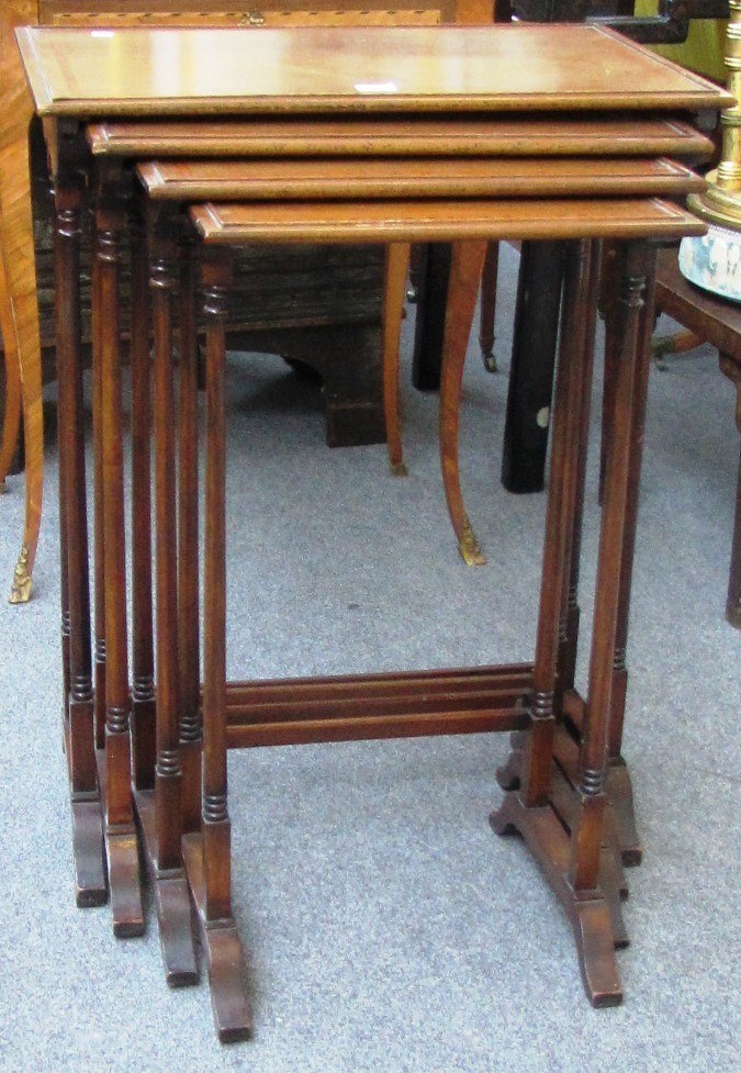 Appraisal: A nest of four Edwardian satinwood banded mahogany tables on