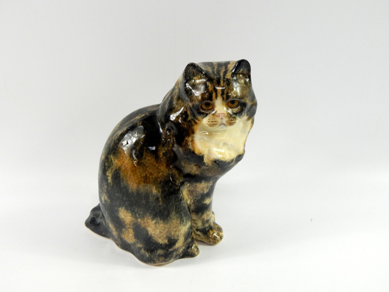 Appraisal: A pottery figure of a Winstanley cat modelled seated with